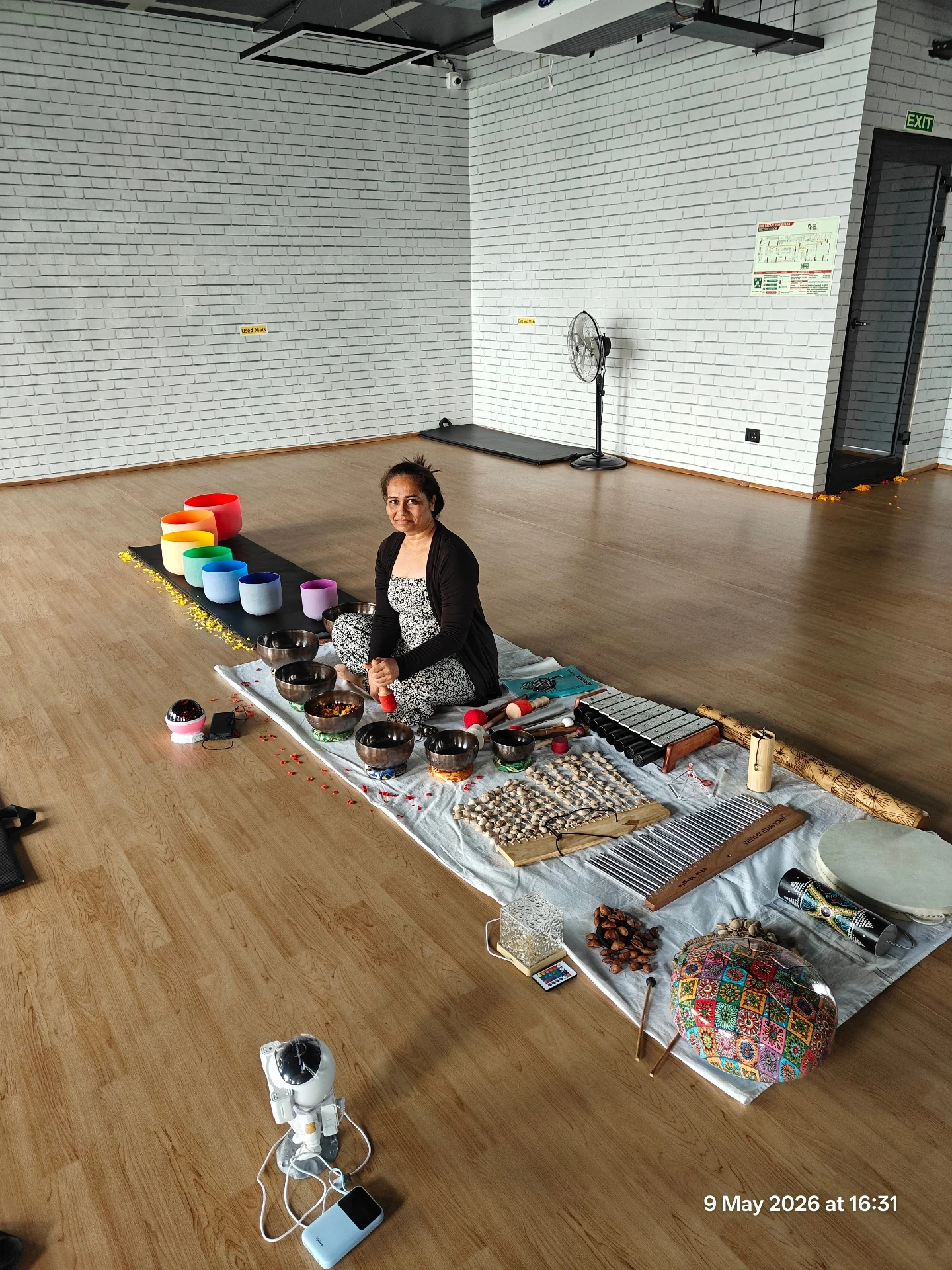 Jigisha Parikh seated with the complete Sound Healing setup of Crystal Bowls Full Moon Bowls Full Moon Metal Singing Bowls Wind Chimes and accessories at Yoga With Jigisha Bangalore